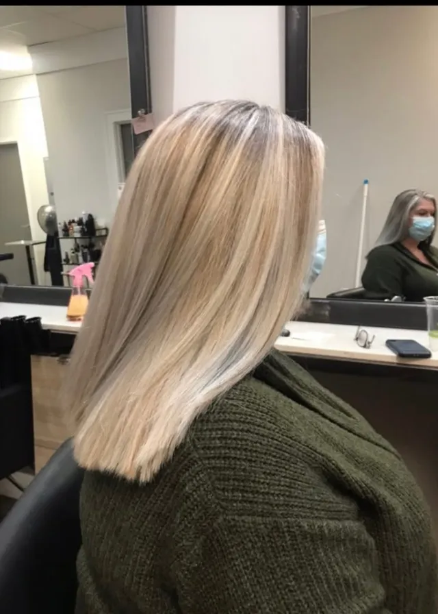 Creamy honey-blonde shoulder-length hair with subtle root dimension.