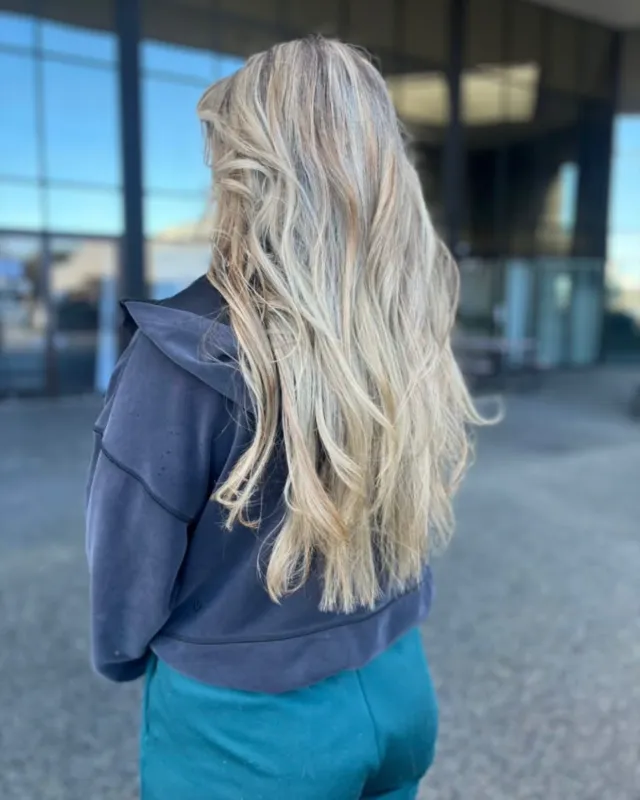 Cool blonde hair with a softened darker root and texture.