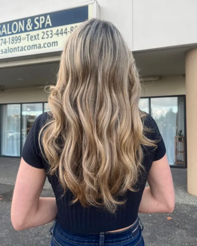 Long warm blonde hair with dimensional lowlights and waves.