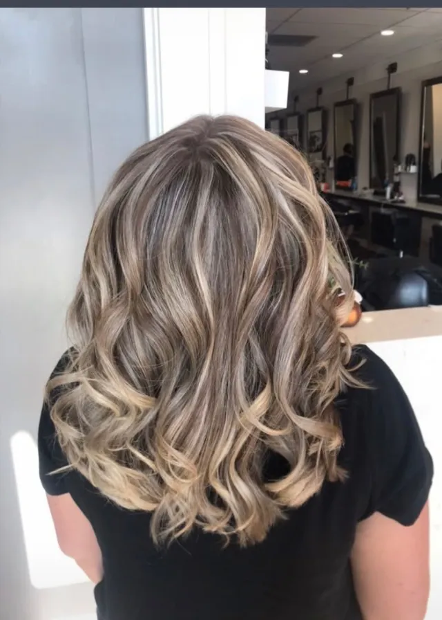 Ash-blonde curled lob with strong contrast dimensional ribbons.