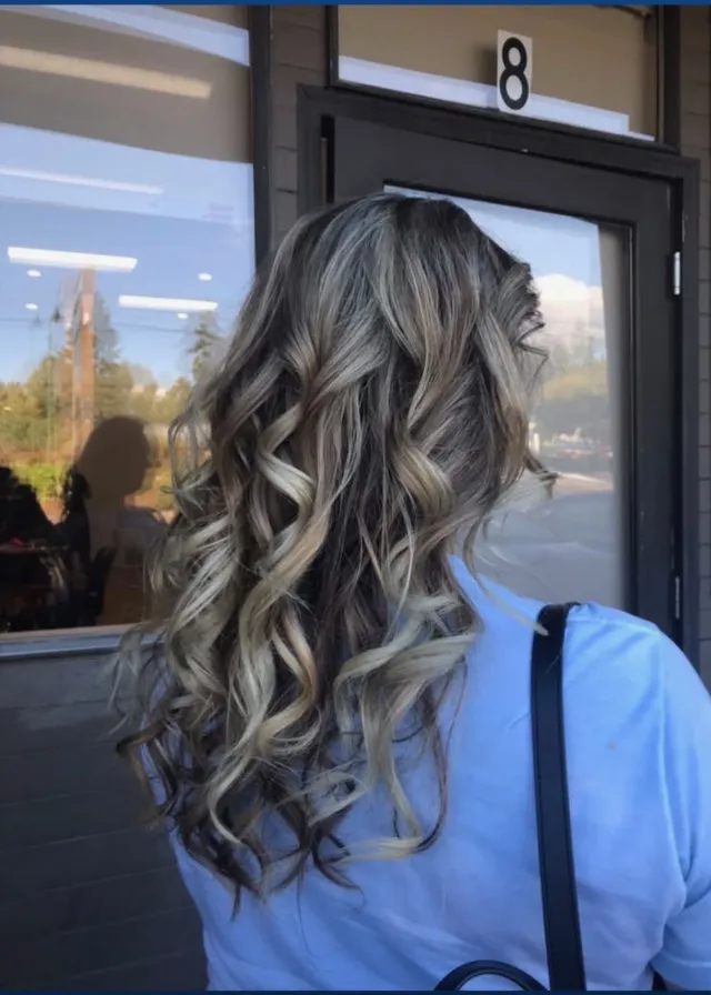 Cool silver and ash highlights on curled brunette hair.