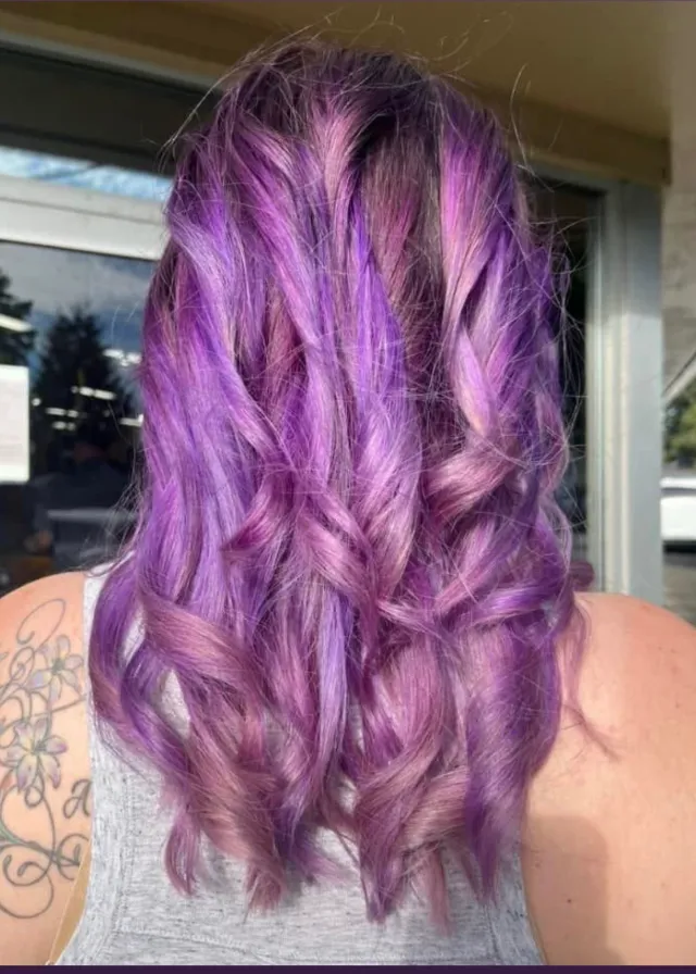 Lavender and violet dimensional hair color styled in loose curls.